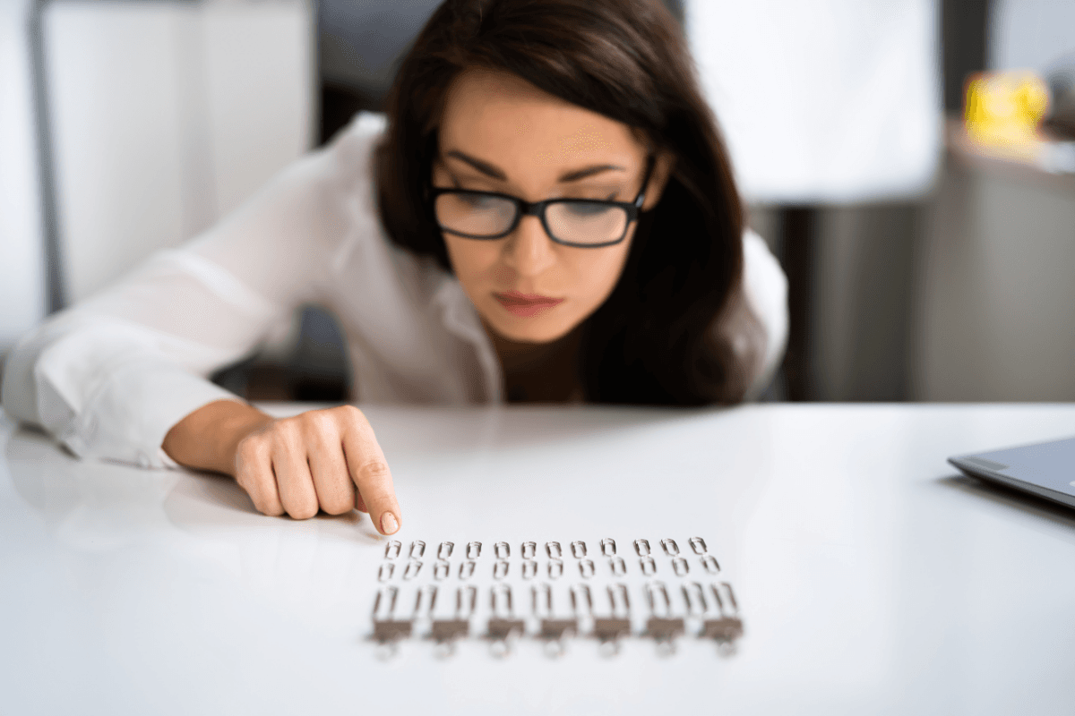 Woman lining up paper clips in neat rows on a desk