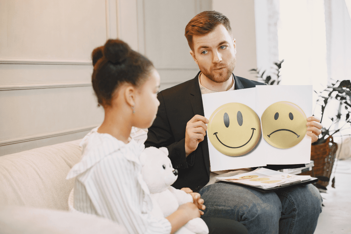 Therapist showing emotion cards to a child during a counseling session